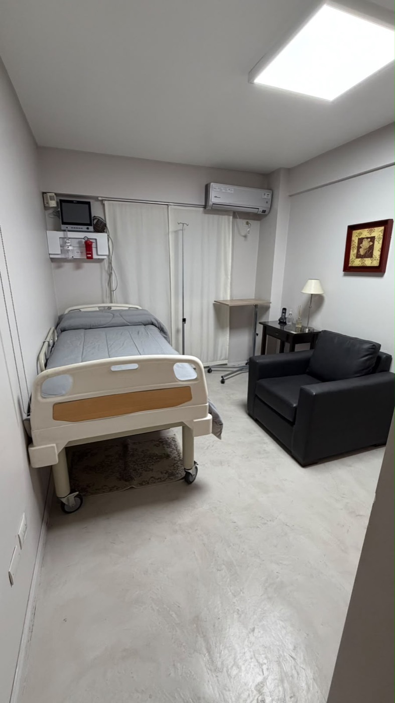 Habitación individual de recuperación con cama articulada y sillón